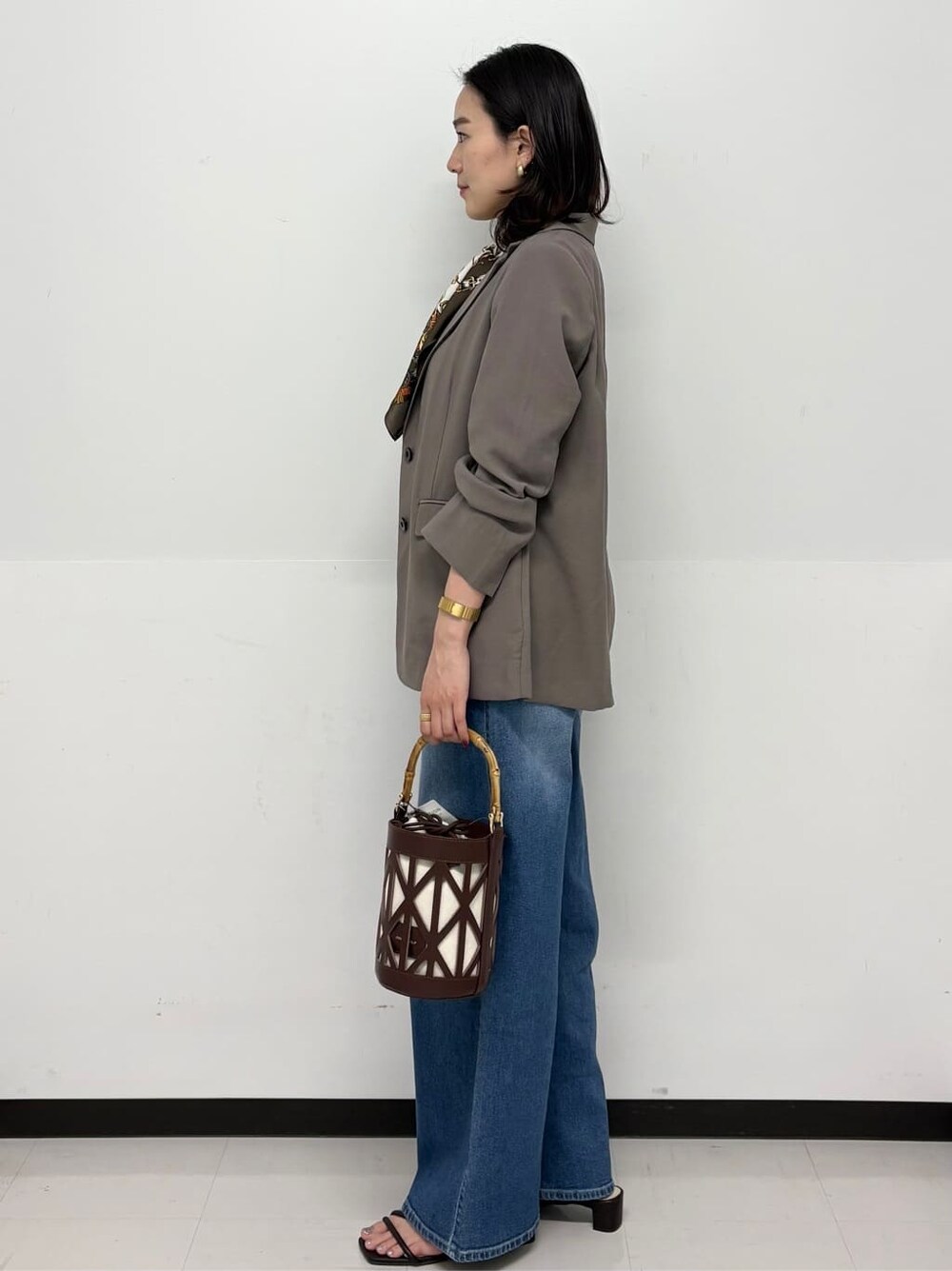 ブルー系のデニムパンツ、ホワイト系のその他パンツ、ブラウン系のテーラードジャケットを着用したレディースの春コーディネートの4枚目の写真