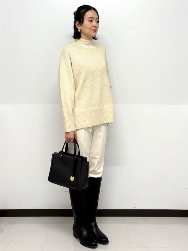 ベージュ系のニット/セーター、ホワイト系のその他パンツ、ブラック系のトートバッグを着用したレディースの秋コーディネートの2枚目の写真