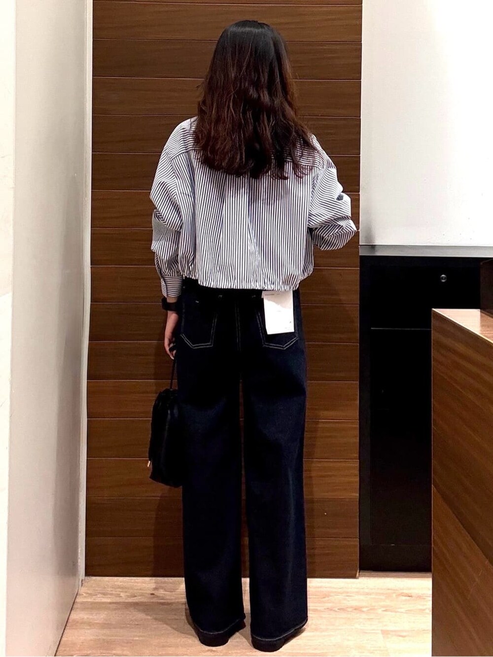 ブルー系のシャツ/ブラウス、ブルー系のデニムパンツ、ブラック系のショルダーバッグを着用したレディースの秋コーディネートの3枚目の写真