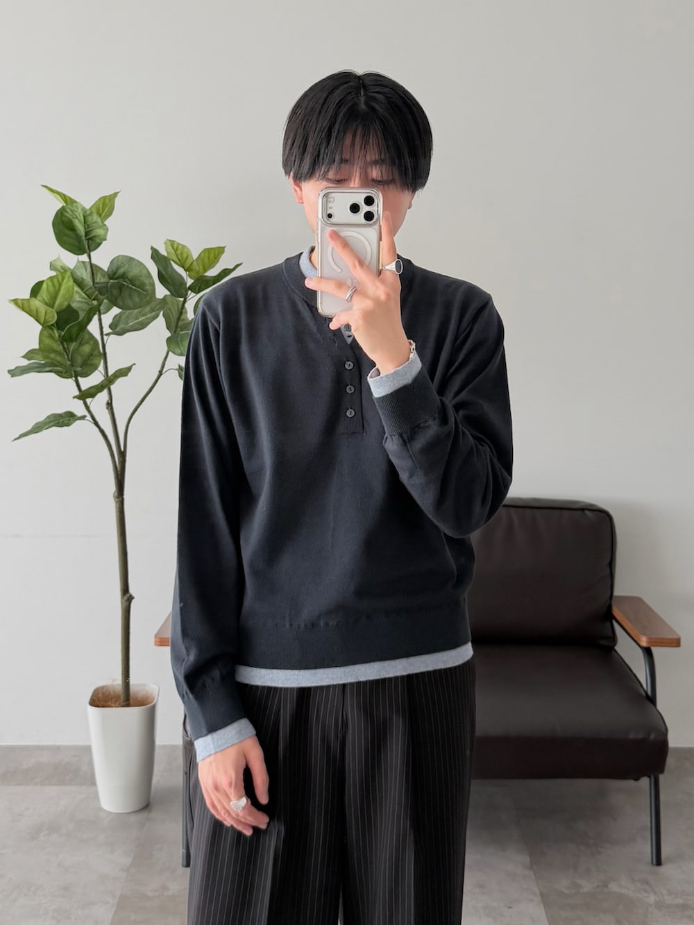 ブルー系のニット/セーター、ブラック系のスラックスを着用したメンズの春コーディネートの2枚目の写真