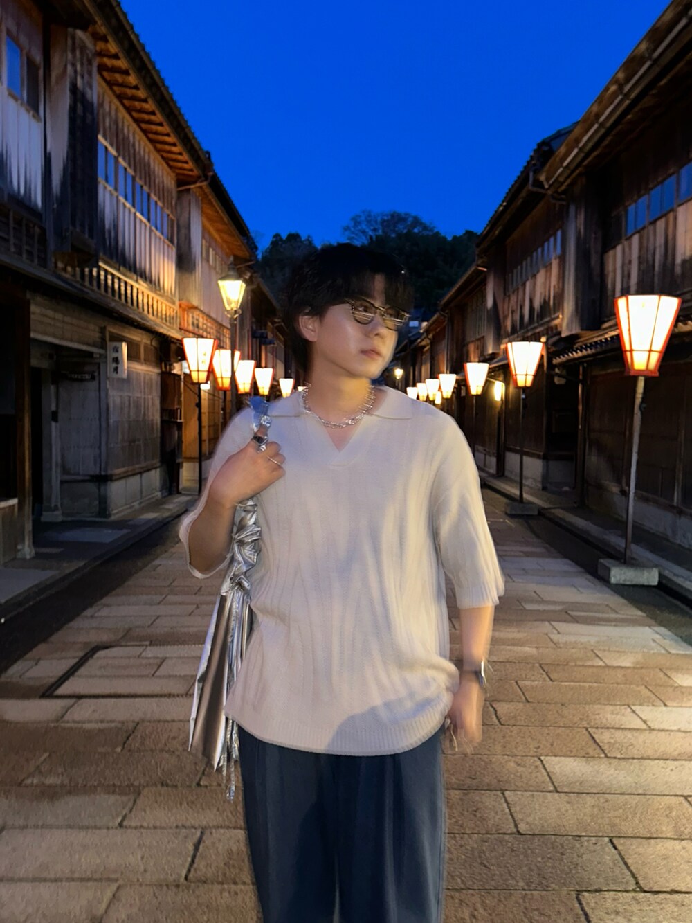 ホワイト系のポロシャツ、ブルー系のデニムパンツ、シルバー系のショルダーバッグを着用したメンズの夏コーディネートの4枚目の写真