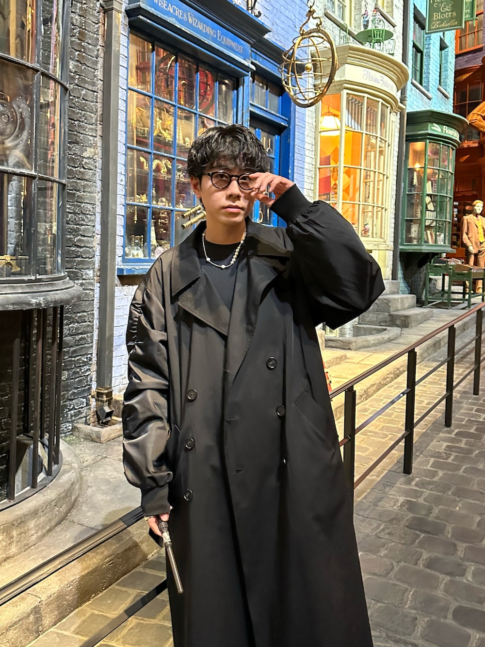 ブラック系のトレンチコート、ブルー系のデニムパンツを着用したメンズの秋コーディネートの3枚目の写真