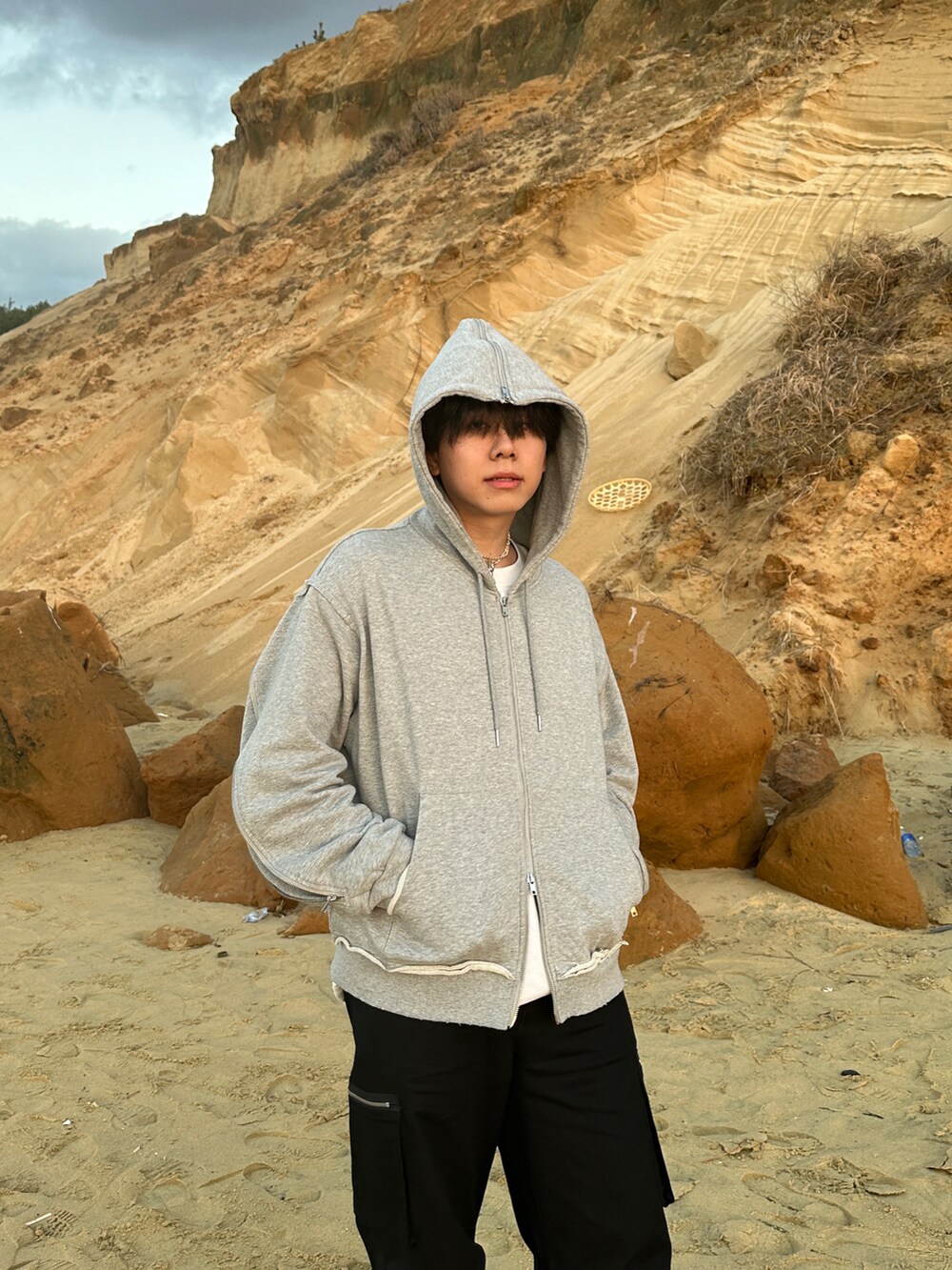 ブラック系のモッズコート、ブラック系のカーゴパンツ、ブラック系のブーツを着用したメンズの冬コーディネートの3枚目の写真