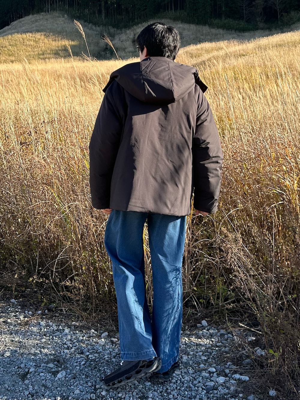 ブラック系のブルゾン、ブルー系のデニムパンツを着用したメンズの秋コーディネートの2枚目の写真