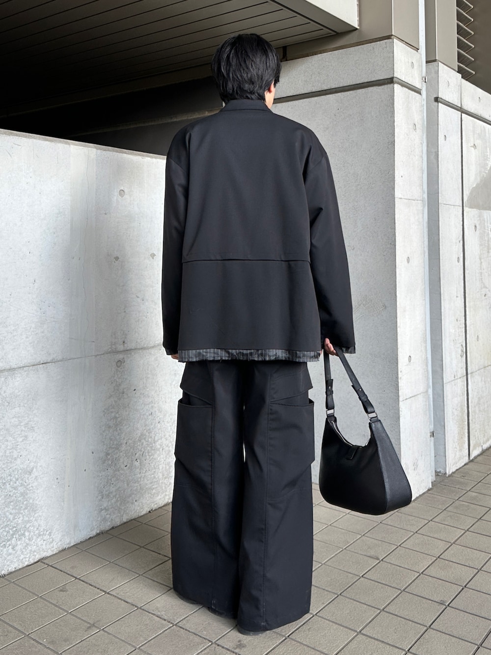 ブラック系のブーツ、ブラック系のテーラードジャケット、ブラック系のスラックスを着用したメンズの冬コーディネートの2枚目の写真