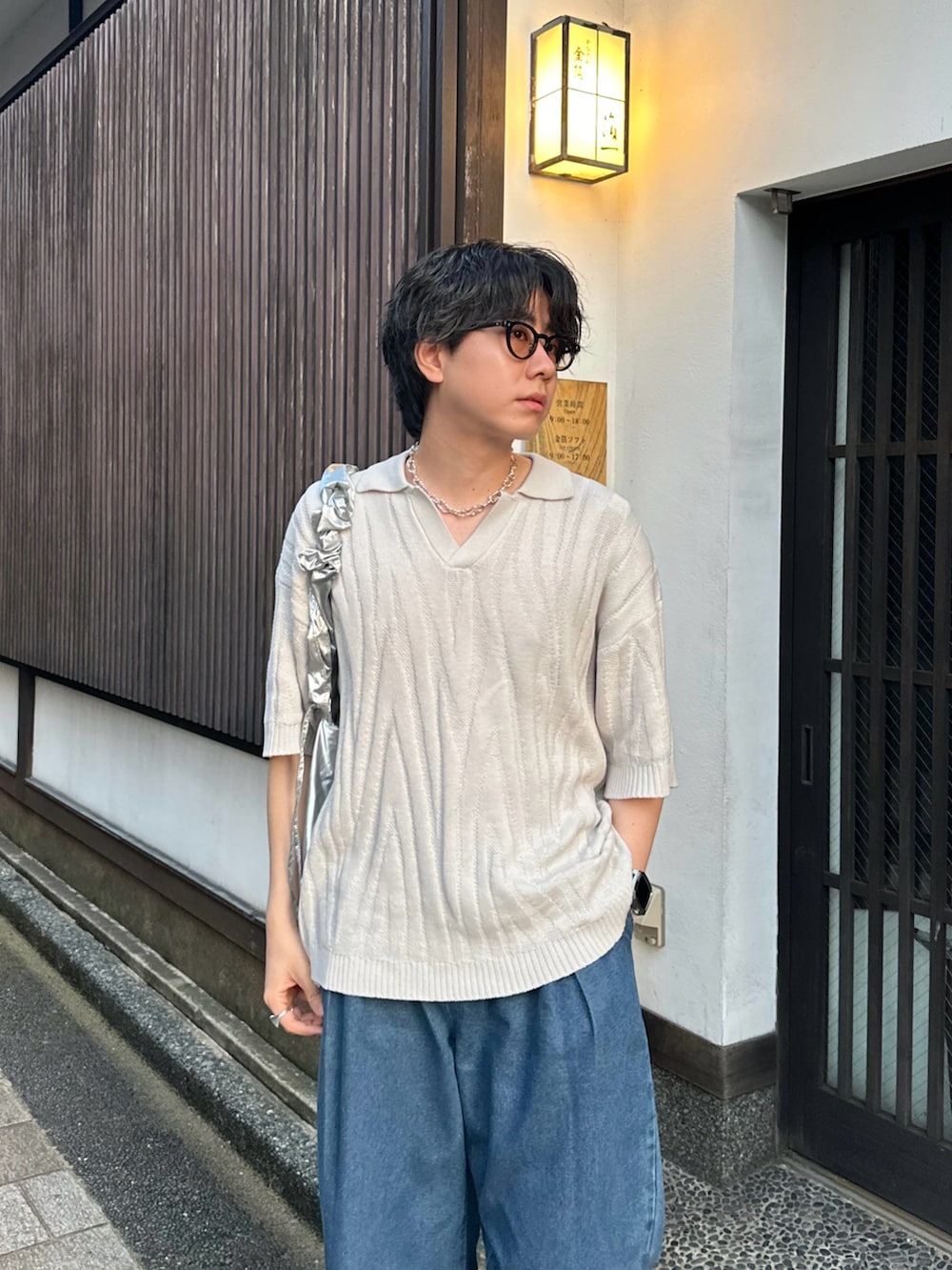 ホワイト系のポロシャツ、ブルー系のデニムパンツ、シルバー系のショルダーバッグを着用したメンズの夏コーディネートの2枚目の写真