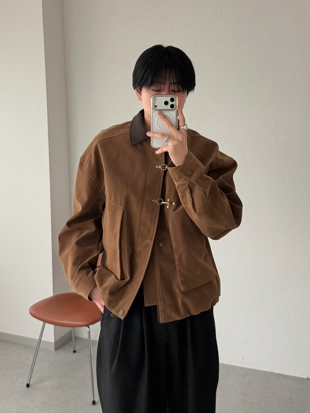 イエロー系のブルゾン、ブラック系のスラックスを着用したメンズの春コーディネートの2枚目の写真