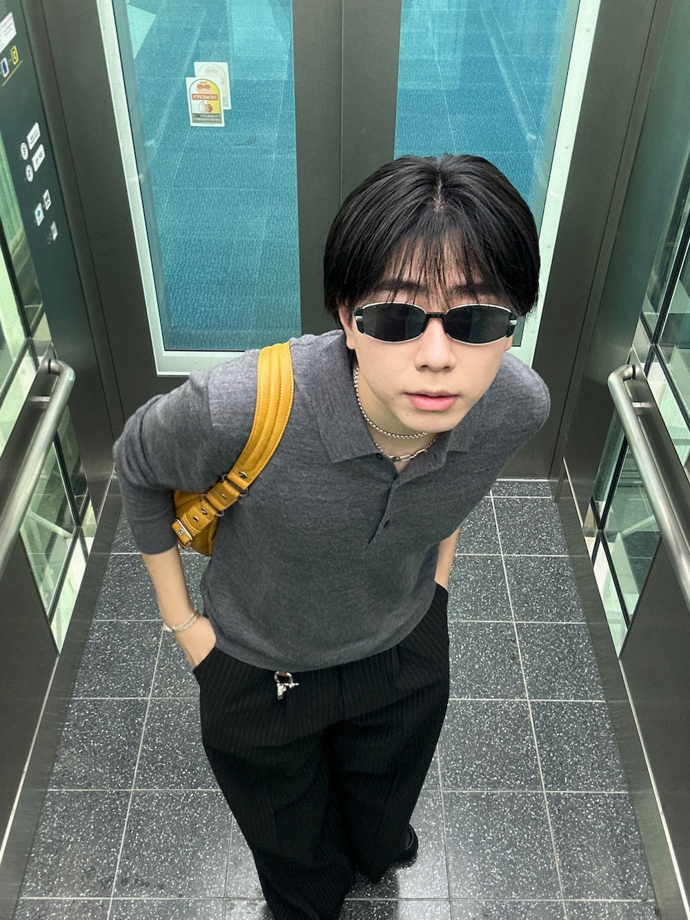 ブラック系のスラックス、ブラック系のハンドバッグを着用したメンズの秋コーディネートの3枚目の写真