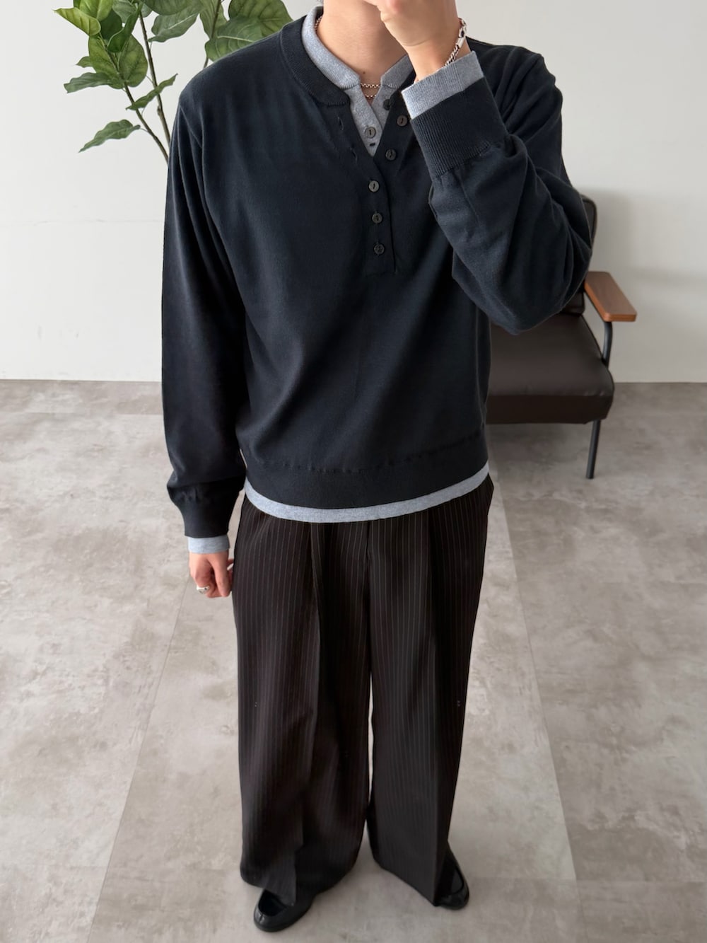 ブルー系のニット/セーター、ブラック系のスラックスを着用したメンズの春コーディネートの3枚目の写真