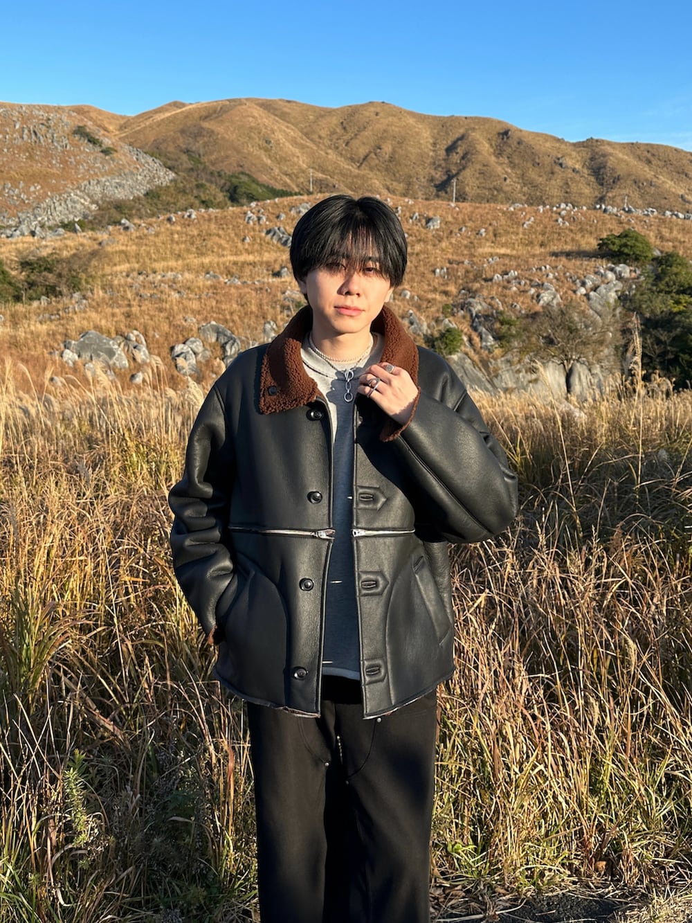 グレー系のスウェット、ブラック系のスラックス、ブラック系のブーツを着用したメンズの冬コーディネートの3枚目の写真