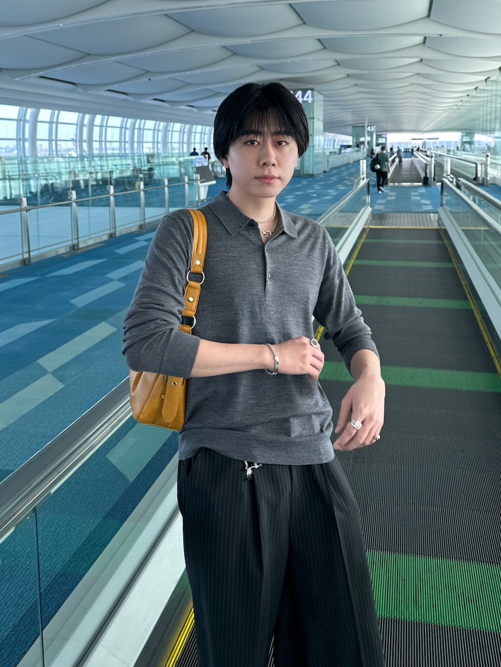 ブラック系のスラックス、ブラック系のハンドバッグを着用したメンズの秋コーディネートの2枚目の写真