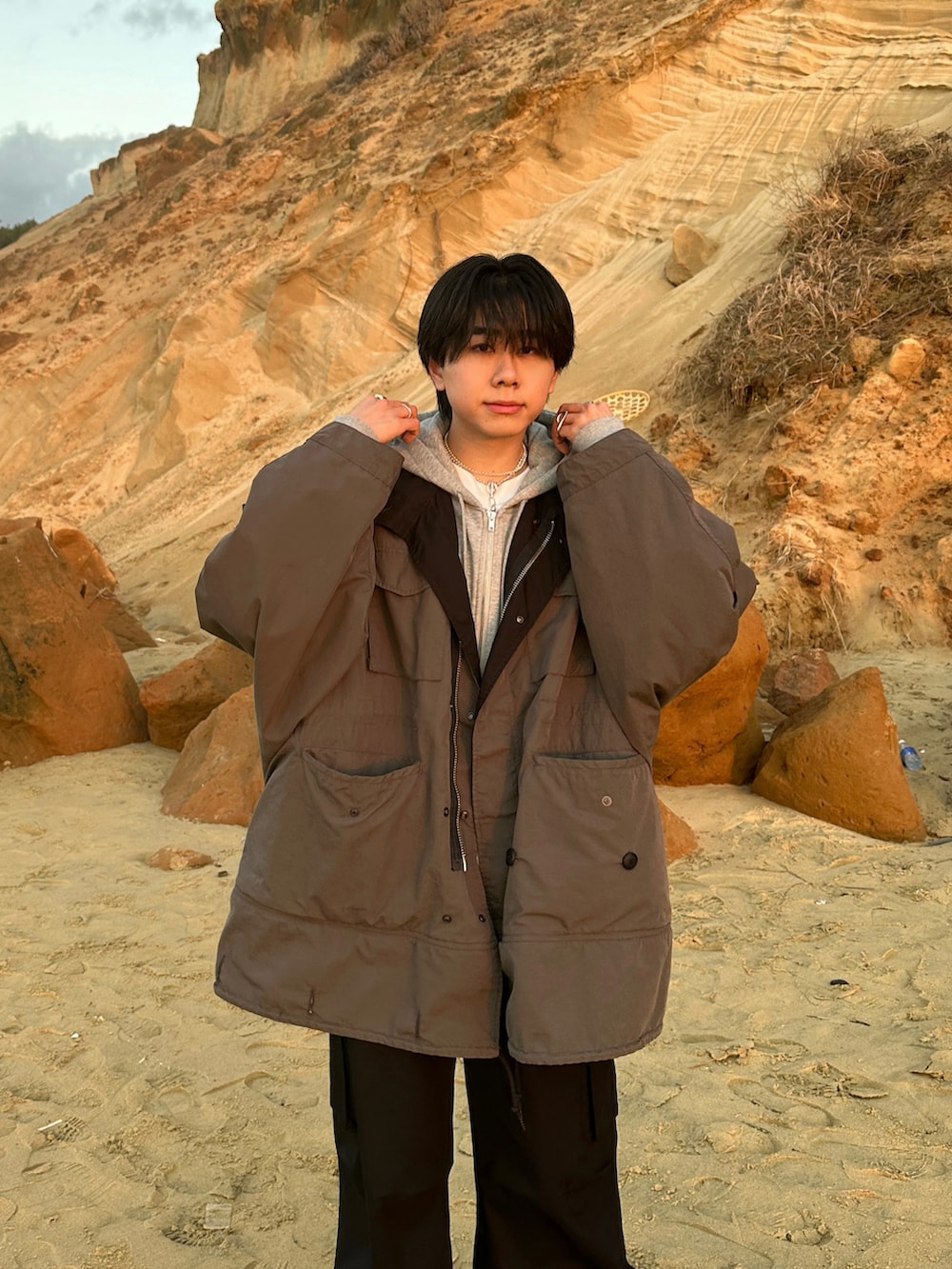 ブラック系のモッズコート、ブラック系のカーゴパンツ、ブラック系のブーツを着用したメンズの冬コーディネートの2枚目の写真