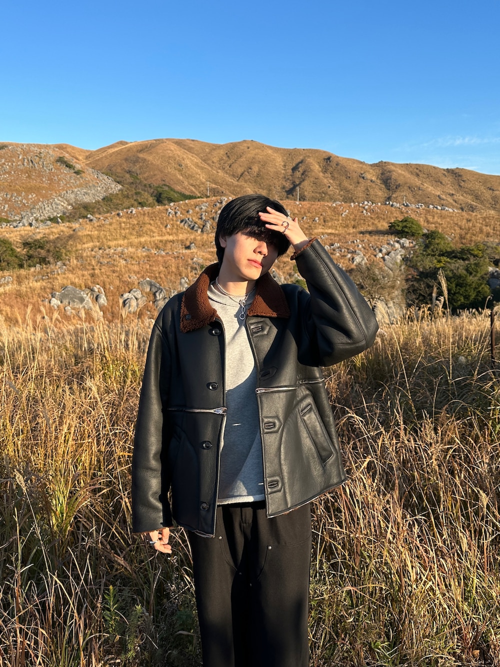 グレー系のスウェット、ブラック系のスラックス、ブラック系のブーツを着用したメンズの冬コーディネートの4枚目の写真