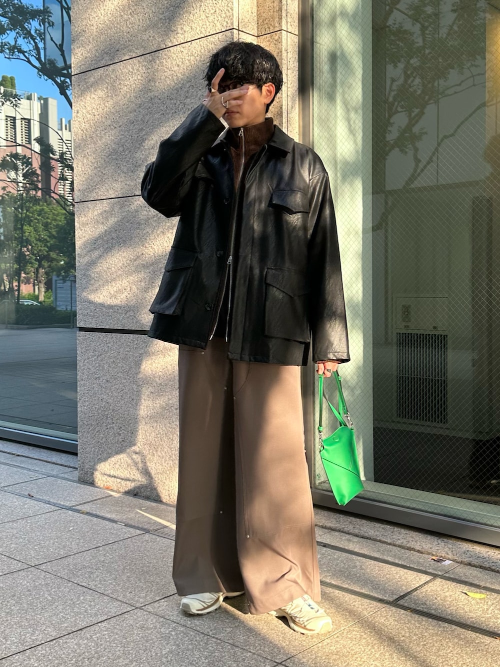 ブラック系のミリタリージャケット、ブラウン系のブルゾン、ベージュ系のスラックスを着用したメンズの秋コーディネートの2枚目の写真