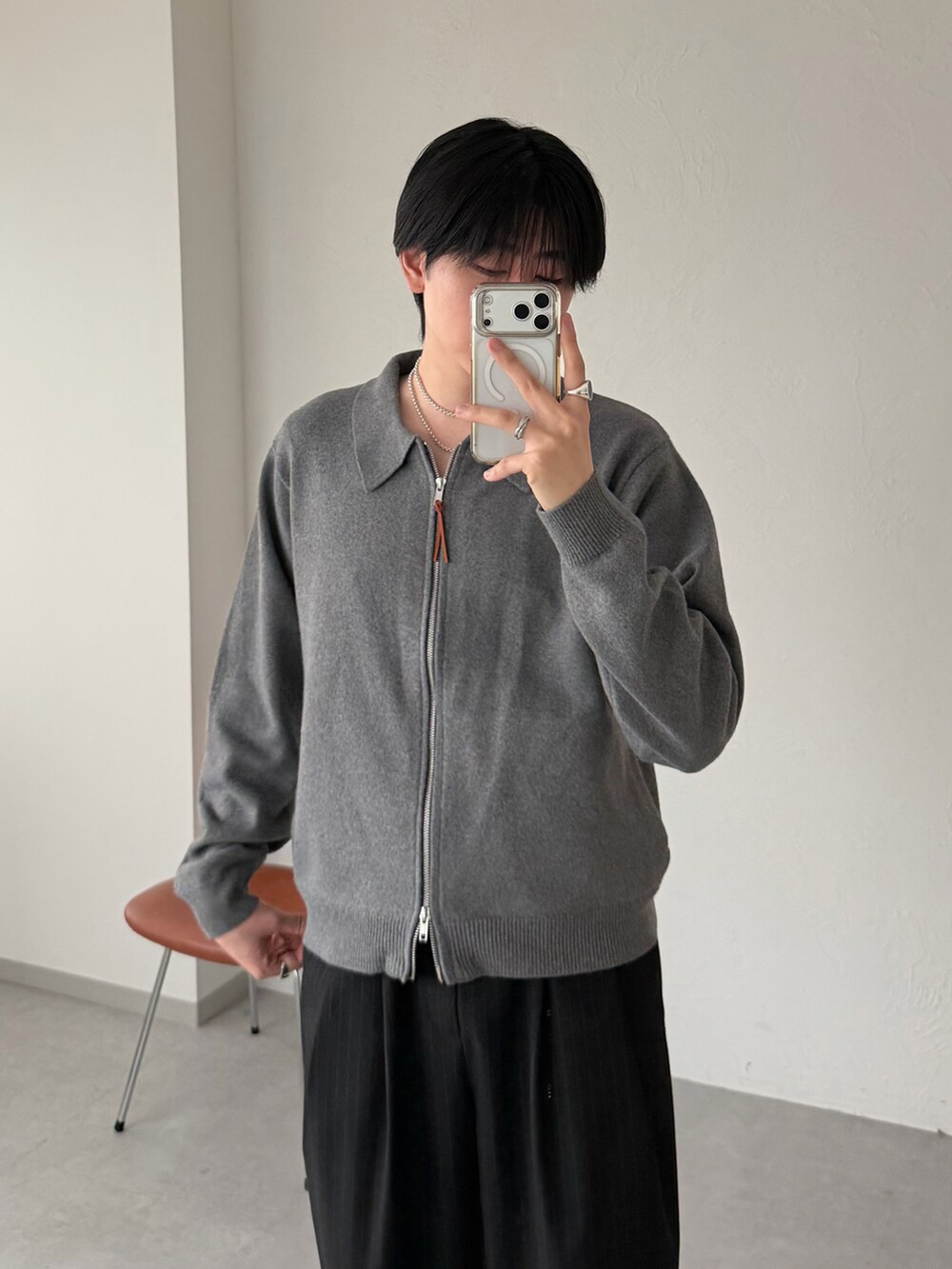 グレー系のニット/セーター、ブラック系のスラックスを着用したメンズの春コーディネートの2枚目の写真
