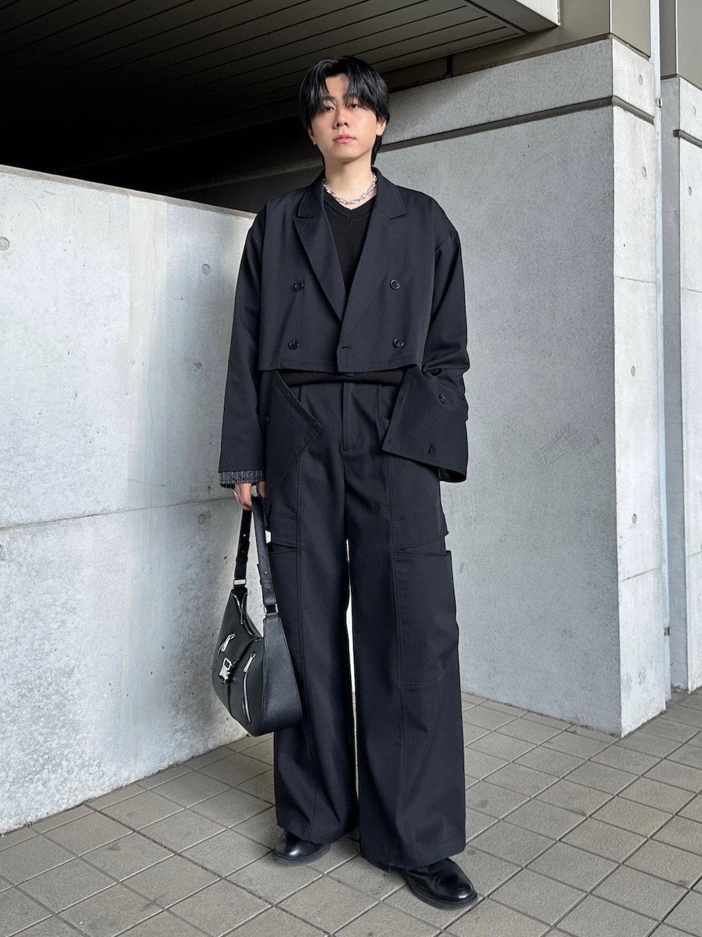 ブラック系のブーツ、ブラック系のテーラードジャケット、ブラック系のスラックスを着用したメンズの冬コーディネートの3枚目の写真