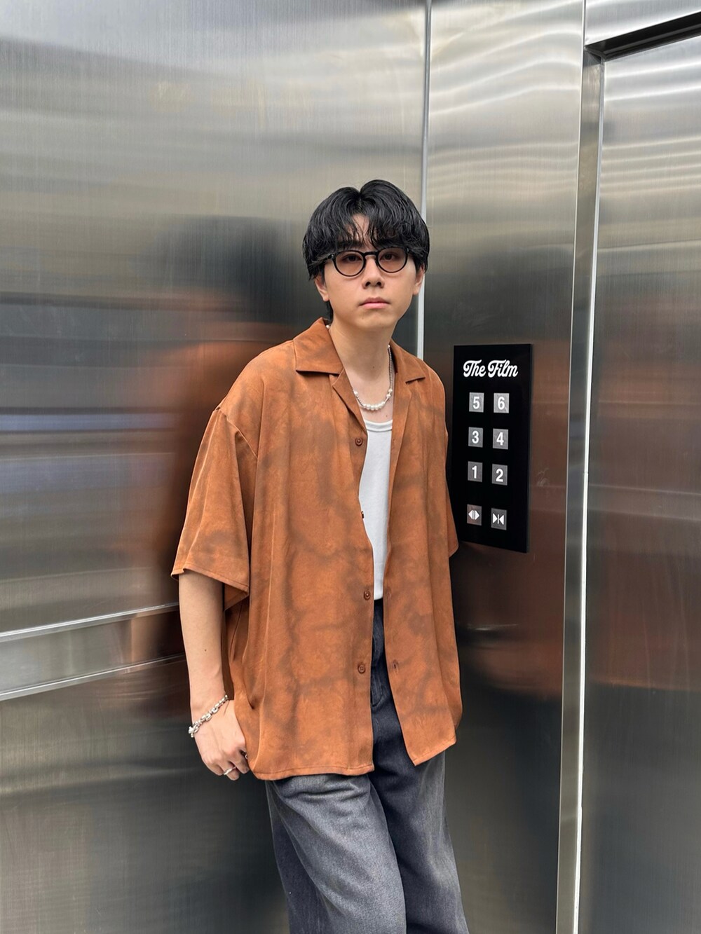 オレンジ系のシャツ/ブラウス、ブラック系のデニムパンツ、ホワイト系のTシャツ/カットソーを着用したメンズの夏コーディネートの3枚目の写真