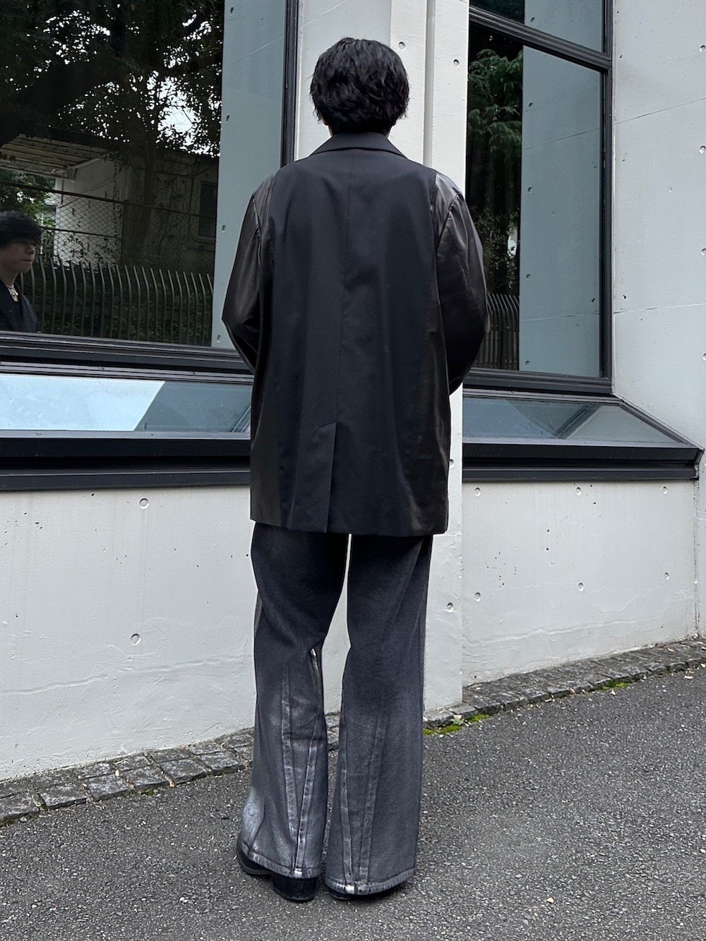 ブラック系のデニムパンツを着用したメンズの秋コーディネートの2枚目の写真