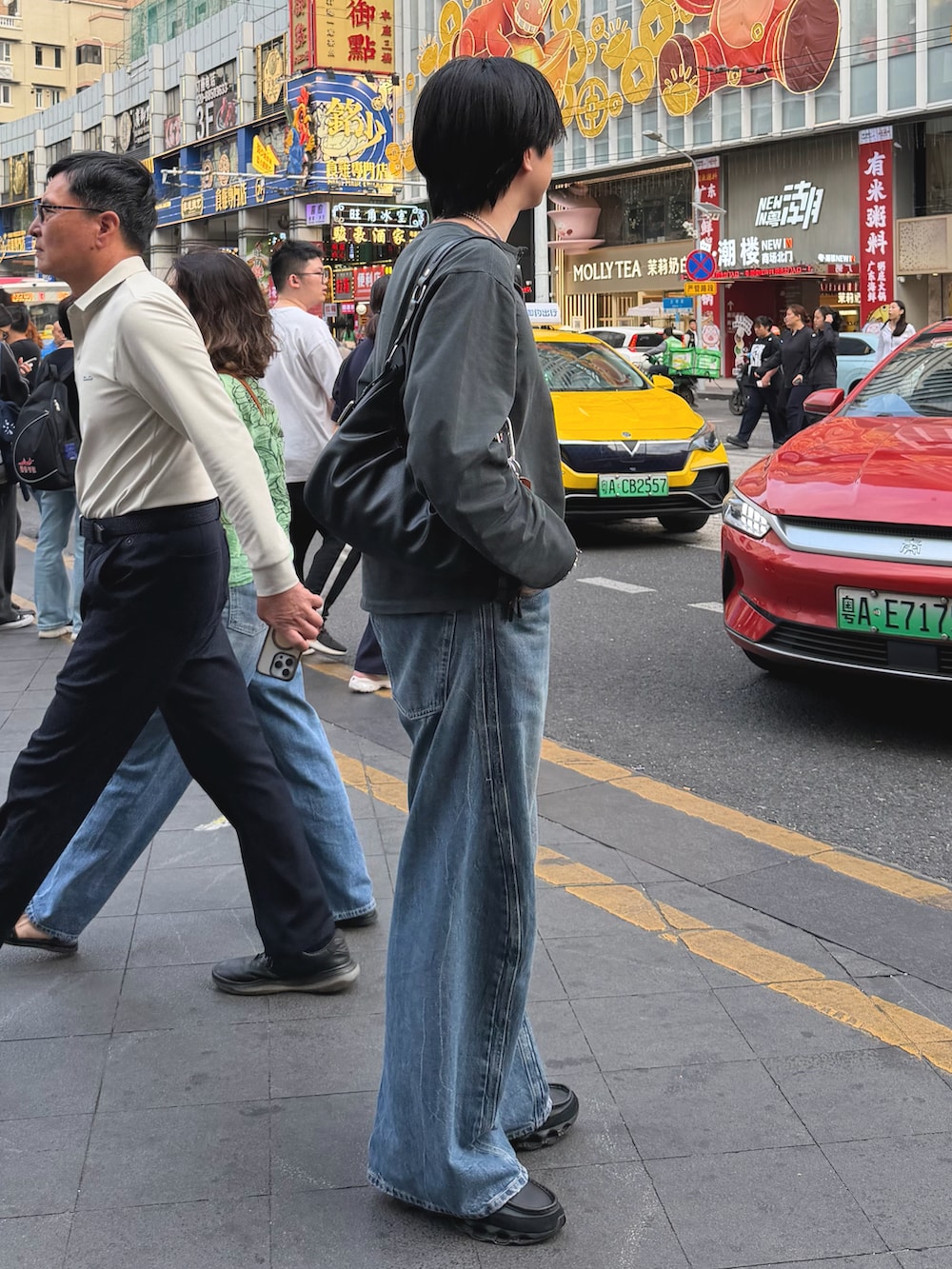 グレー系のTシャツ/カットソー、ブラック系のハンドバッグ、ブルー系のデニムパンツを着用したメンズの春コーディネートの2枚目の写真