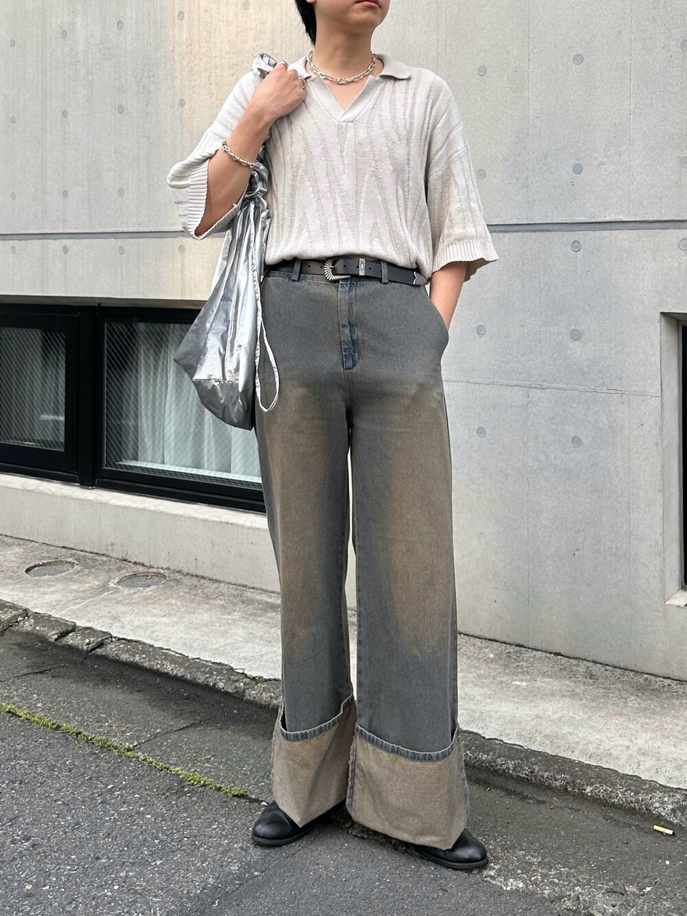 ホワイト系のポロシャツ、シルバー系のショルダーバッグ、ブルー系のデニムパンツを着用したメンズの夏コーディネートの2枚目の写真