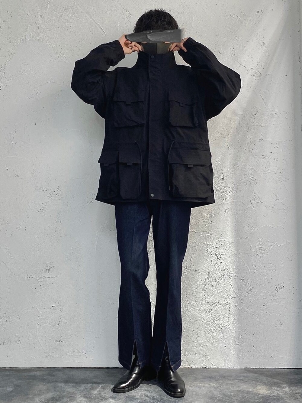 ブラック系のミリタリージャケット、ブルー系のその他パンツ、ブラック系のショルダーバッグを着用したメンズの冬コーディネートの3枚目の写真