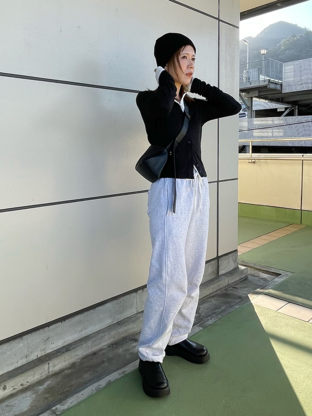 ブラック系のカーディガン/ボレロ、ホワイト系のカーディガン/ボレロ、グレー系のスウェットパンツを着用したレディースの春コーディネートの5枚目の写真