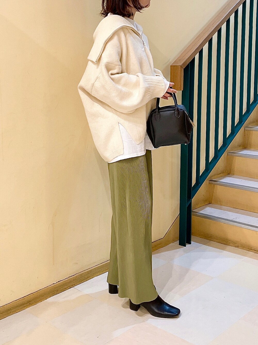 ホワイト系のニット/セーター、グリーン系のその他パンツ、ブラック系のブーツを着用したレディースの冬コーディネートの2枚目の写真