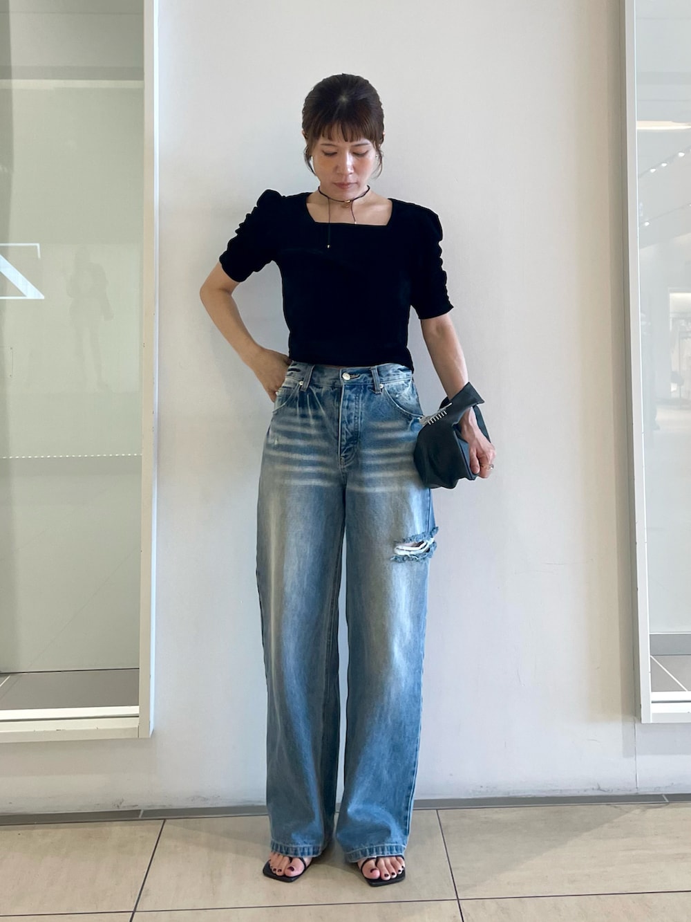 ブラック系のTシャツ/カットソー、ブルー系のデニムパンツ、ブラック系のサンダルを着用したレディースの夏コーディネートの2枚目の写真