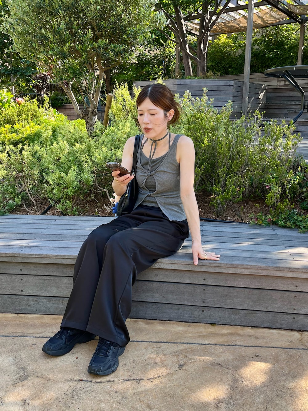 ブラック系のその他パンツ、ブラック系のスニーカー、ブラック系のハンドバッグを着用したレディースの夏コーディネートの5枚目の写真