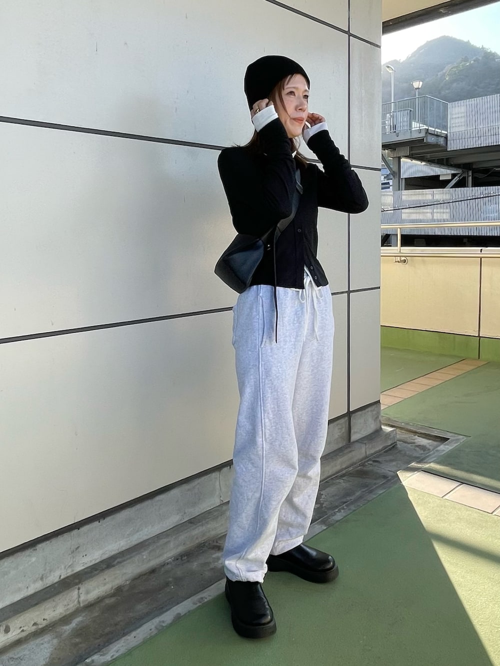 ブラック系のカーディガン/ボレロ、ホワイト系のカーディガン/ボレロ、グレー系のスウェットパンツを着用したレディースの春コーディネートの4枚目の写真