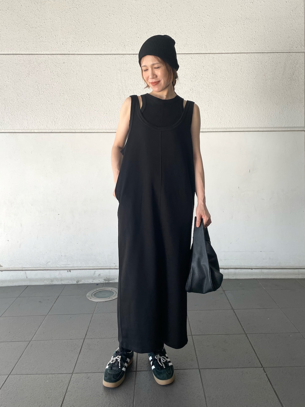 ブラック系のワンピース、ブラック系のスニーカー、ブラック系のシューズアクセサリーを着用したレディースの夏コーディネートの2枚目の写真