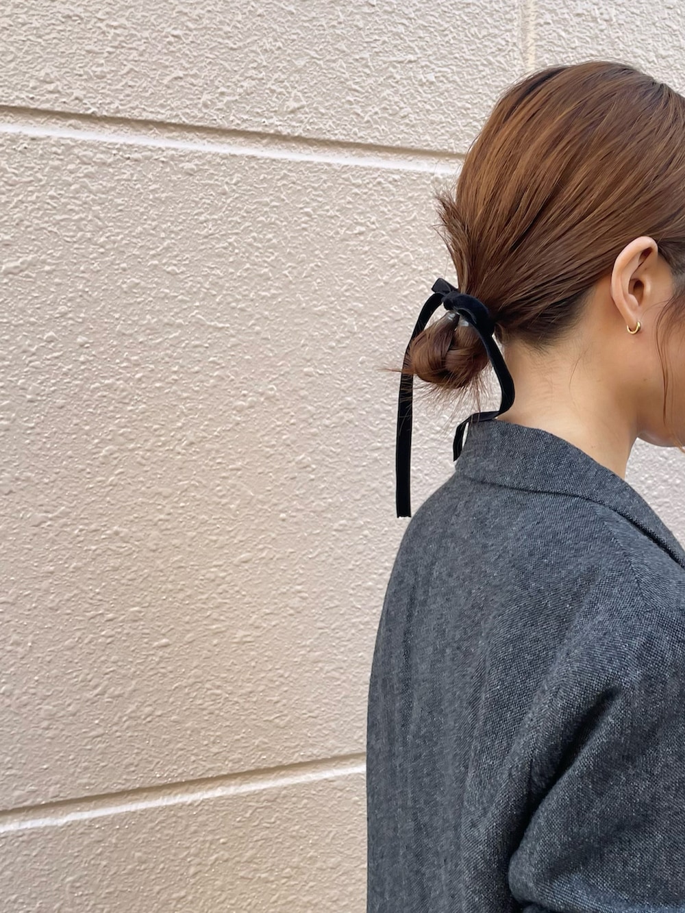 グレー系のテーラードジャケット、グレー系のワンピース、ブラック系のブーツを着用したレディースの春コーディネートの4枚目の写真