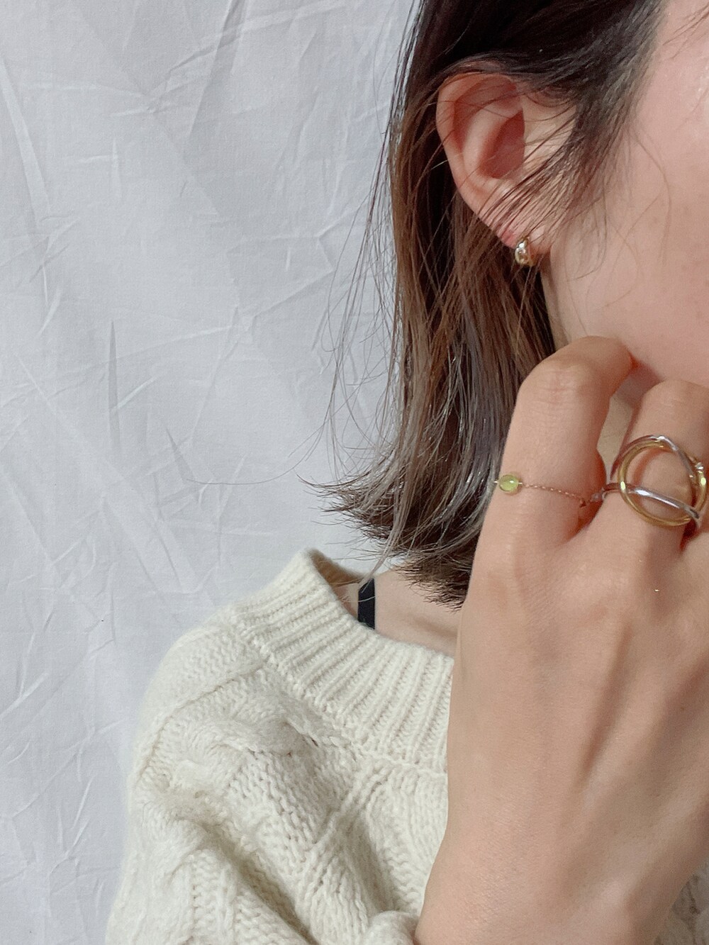 ブラック系のブーツ、ベージュ系のショルダーバッグ、グリーン系のリングを着用したレディースの冬コーディネートの4枚目の写真