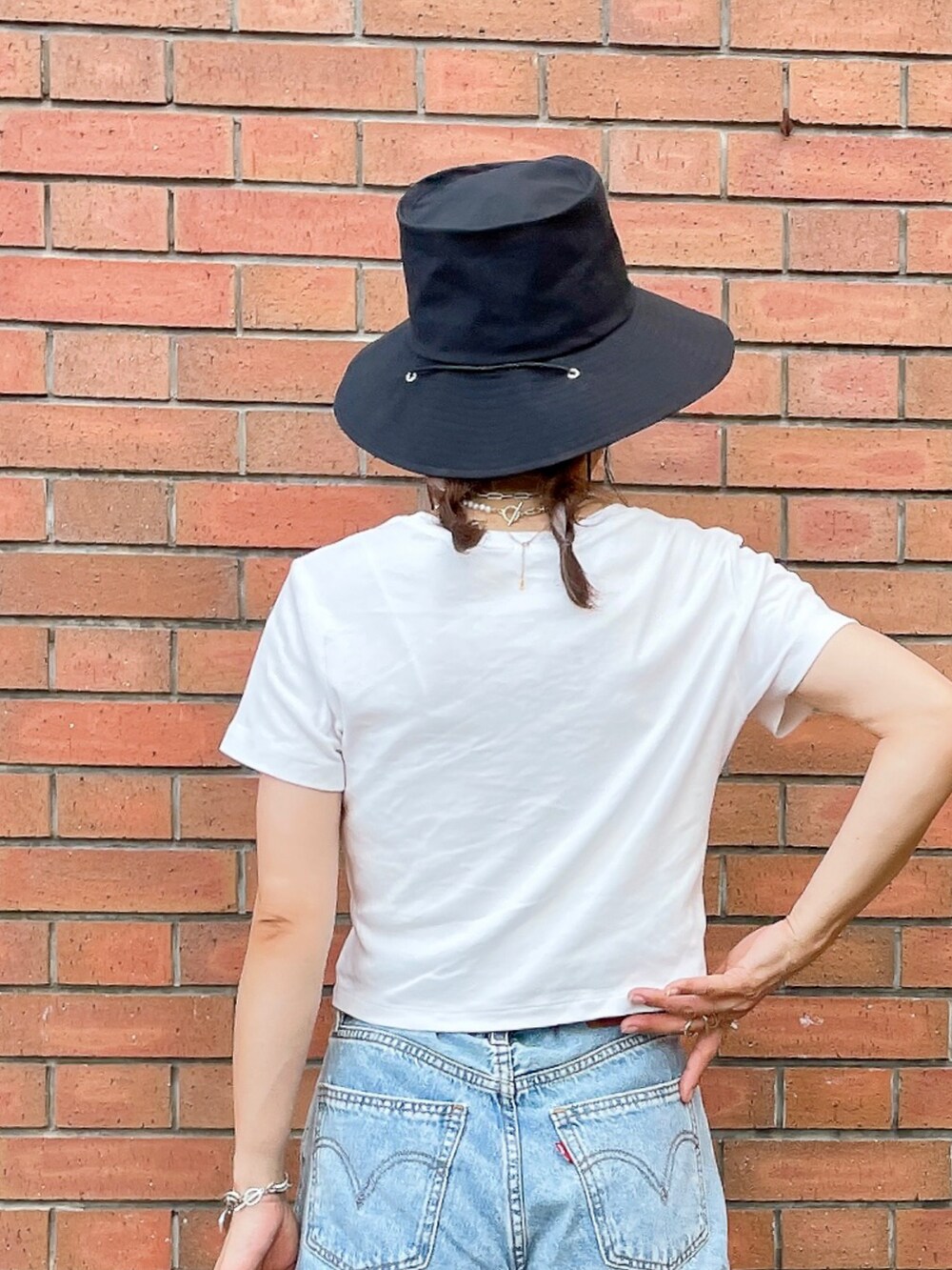 ホワイト系のTシャツ/カットソー、ブルー系のデニムパンツ、ブラック系のサンダルを着用したレディースの夏コーディネートの3枚目の写真