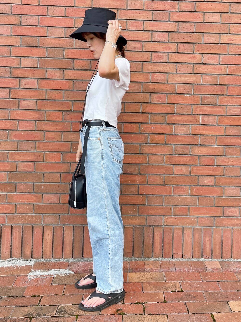 ホワイト系のTシャツ/カットソー、ブルー系のデニムパンツ、ブラック系のサンダルを着用したレディースの夏コーディネートの2枚目の写真