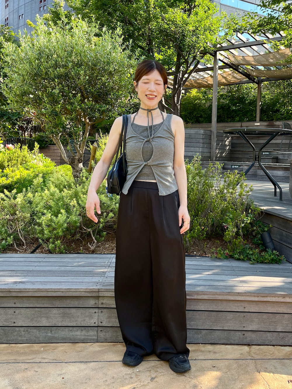 ブラック系のその他パンツ、ブラック系のスニーカー、ブラック系のハンドバッグを着用したレディースの夏コーディネートの2枚目の写真