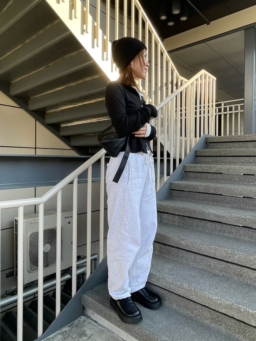 ブラック系のカーディガン/ボレロ、ホワイト系のカーディガン/ボレロ、グレー系のスウェットパンツを着用したレディースの春コーディネートの3枚目の写真