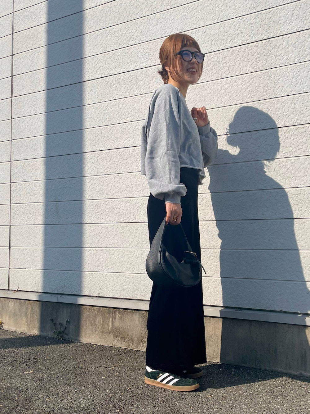 グレー系のスウェット、ブラック系のスニーカー、ブラック系のメガネを着用したレディースの春コーディネートの2枚目の写真