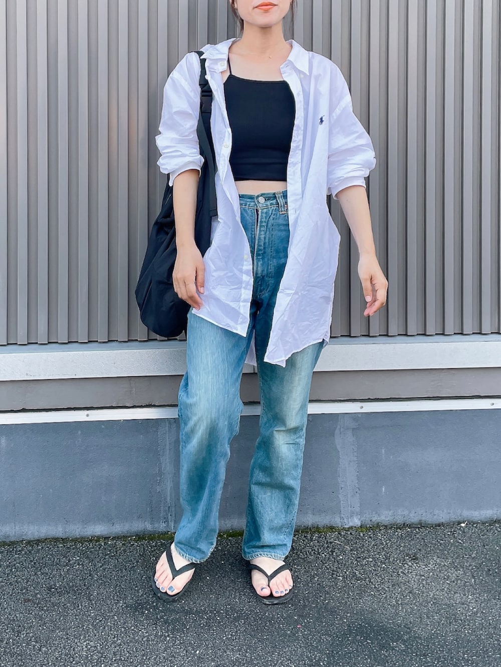 ホワイト系のシャツ/ブラウス、ブルー系のデニムパンツ、ブラック系のビーチサンダルを着用したレディースの夏コーディネートの2枚目の写真