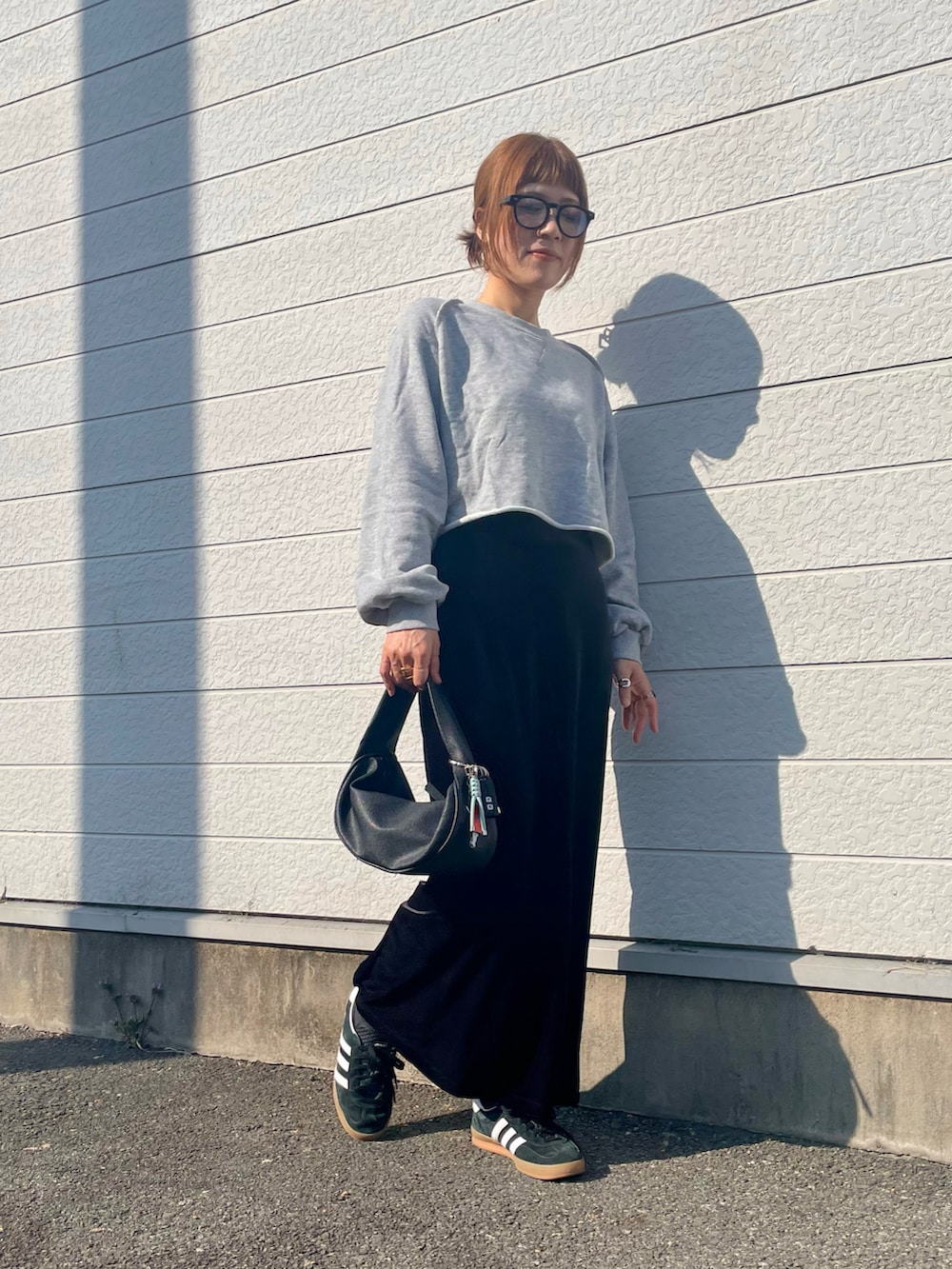 グレー系のスウェット、ブラック系のスニーカー、ブラック系のメガネを着用したレディースの春コーディネートの4枚目の写真