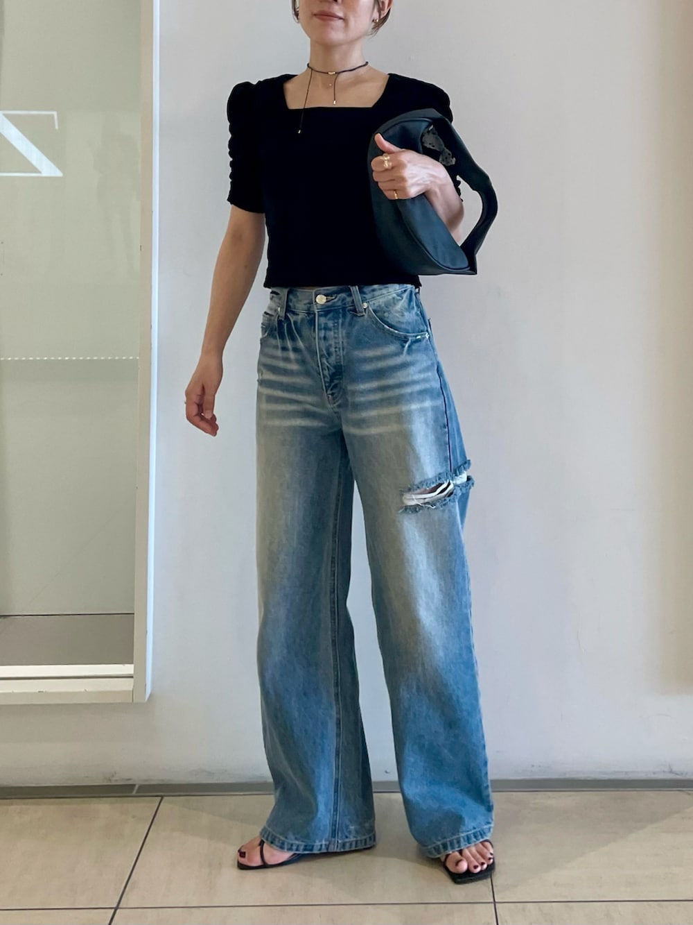 ブラック系のTシャツ/カットソー、ブルー系のデニムパンツ、ブラック系のサンダルを着用したレディースの夏コーディネートの5枚目の写真