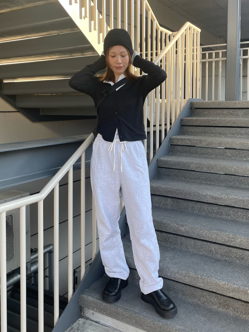 ブラック系のカーディガン/ボレロ、ホワイト系のカーディガン/ボレロ、グレー系のスウェットパンツを着用したレディースの春コーディネートの2枚目の写真