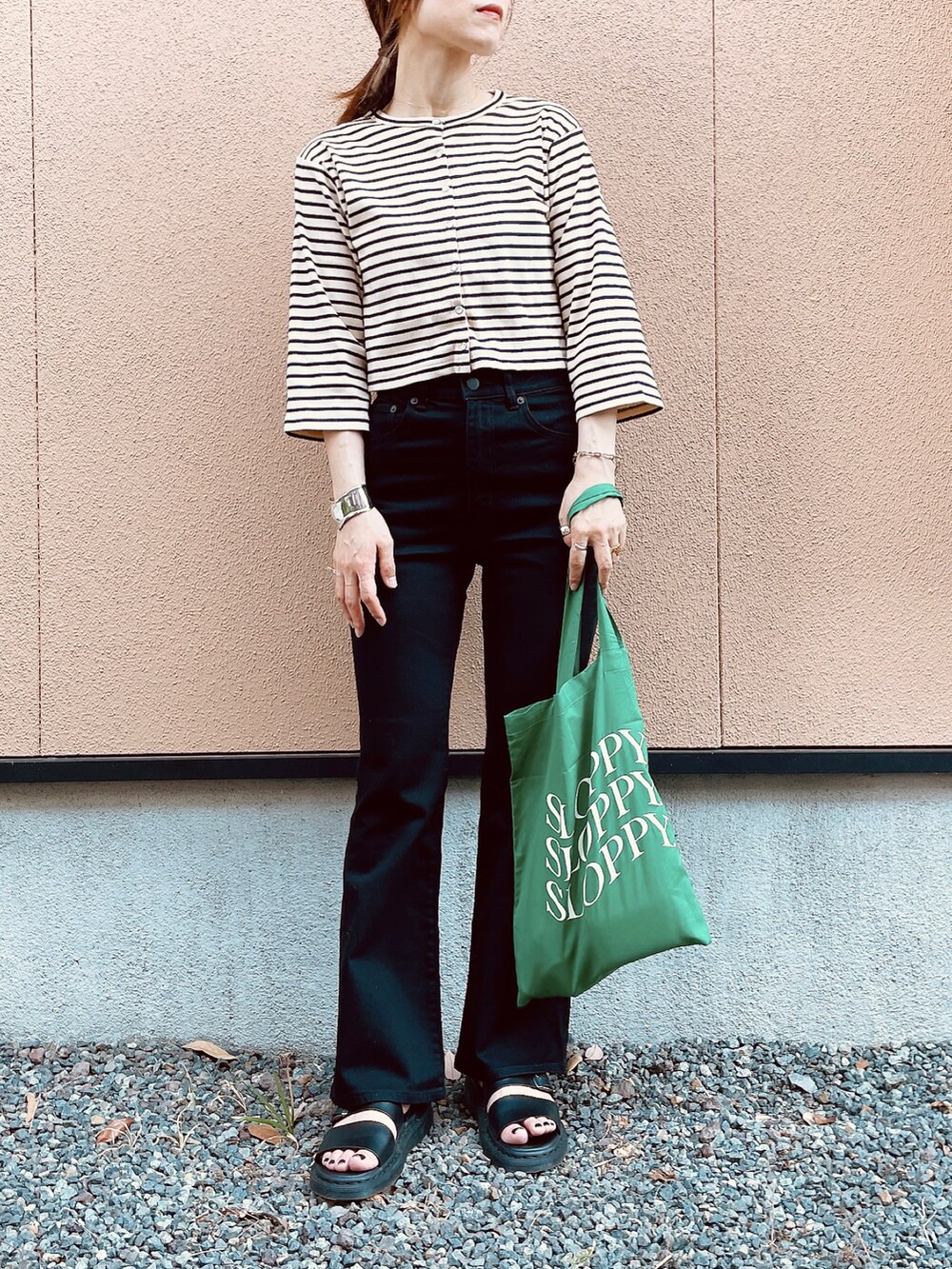 ホワイト系のカーディガン/ボレロ、ブラック系のパンツ、ブラック系のサンダルを着用したレディースの春コーディネートの2枚目の写真