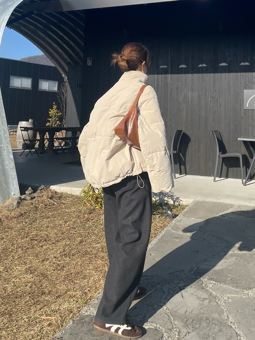 ベージュ系のその他アウター、グレー系のパンツ、ブラウン系のスニーカーを着用したレディースの冬コーディネートの4枚目の写真