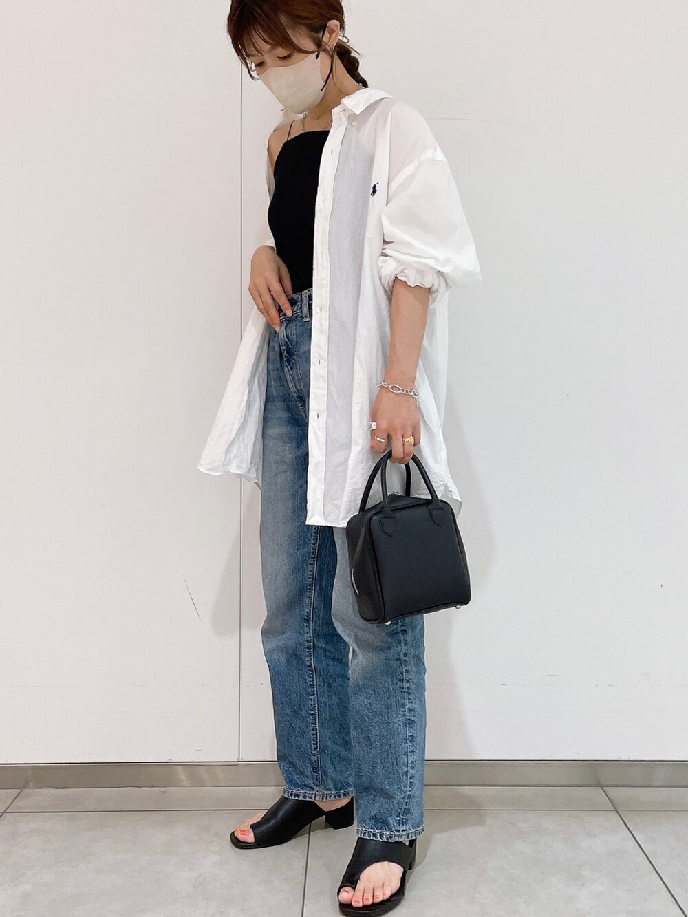 ブラック系のキャミソール、ホワイト系のシャツ/ブラウス、ブルー系のデニムパンツを着用したレディースの夏コーディネートの4枚目の写真