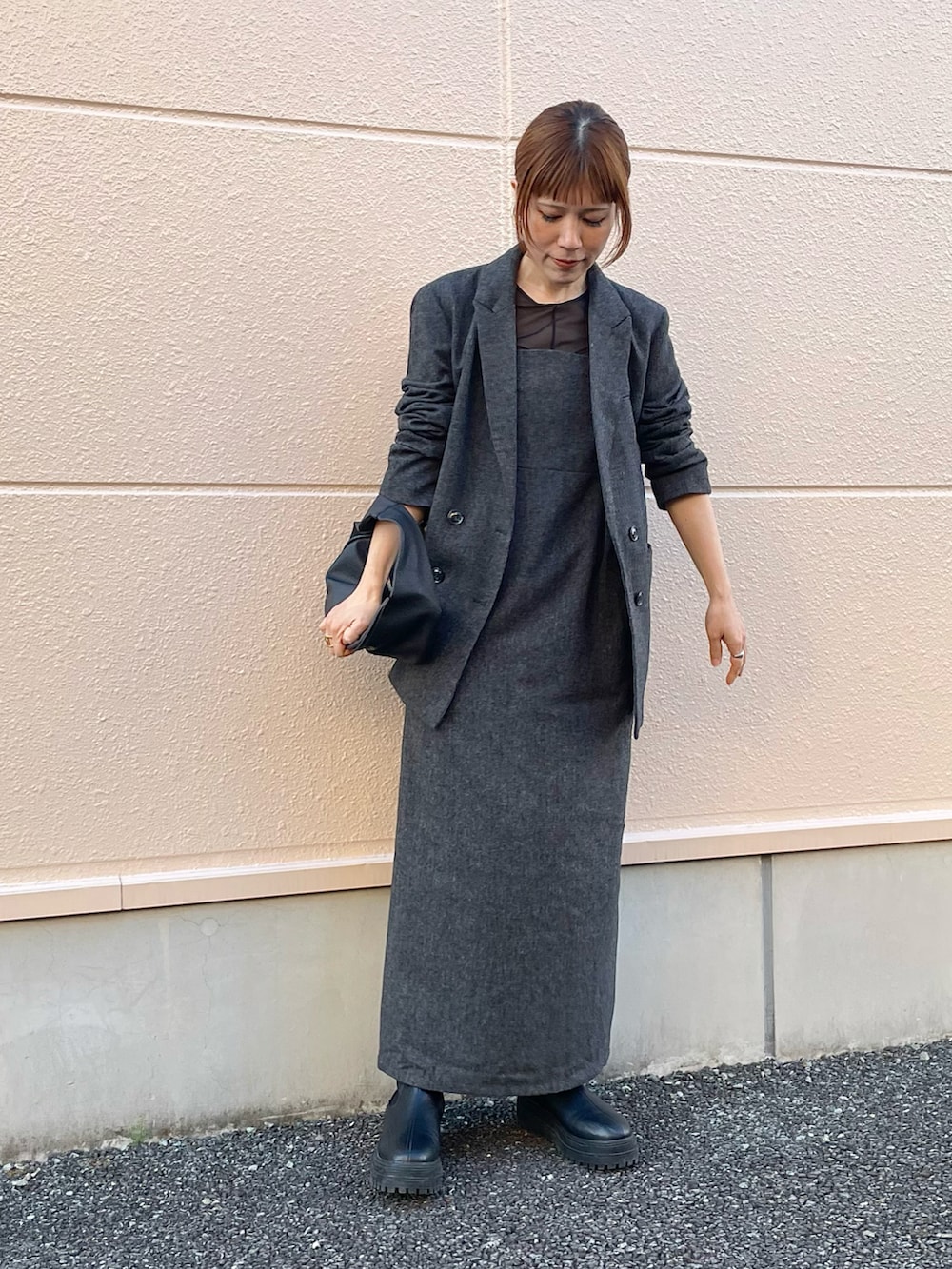 グレー系のテーラードジャケット、グレー系のワンピース、ブラック系のブーツを着用したレディースの春コーディネートの3枚目の写真