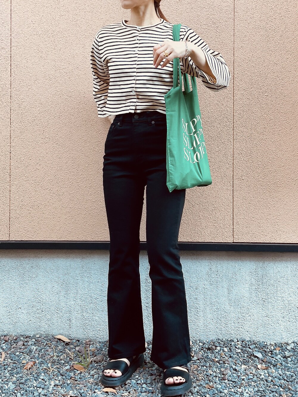 ホワイト系のカーディガン/ボレロ、ブラック系のパンツ、ブラック系のサンダルを着用したレディースの春コーディネートの3枚目の写真