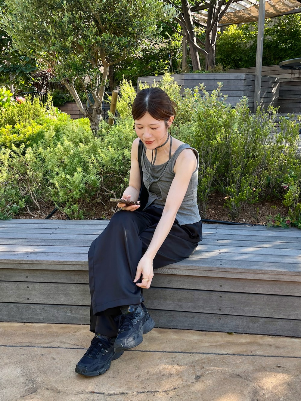ブラック系のその他パンツ、ブラック系のスニーカー、ブラック系のハンドバッグを着用したレディースの夏コーディネートの4枚目の写真