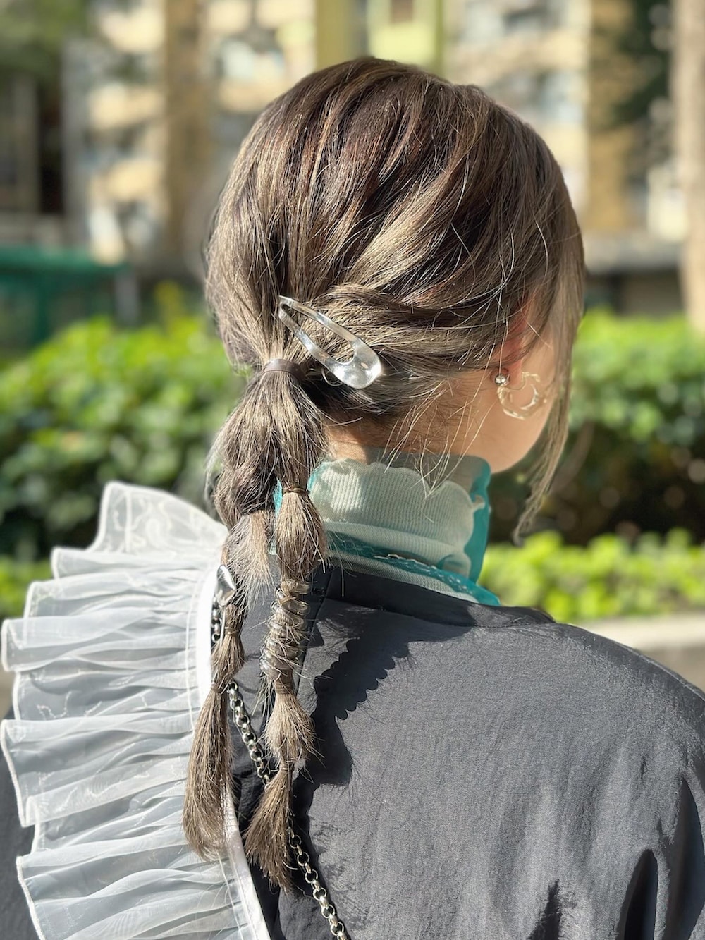 ブラック系のノーカラーコート、シルバー系のショルダーバッグ、ベージュ系のスカートを着用したレディースの冬コーディネートの2枚目の写真