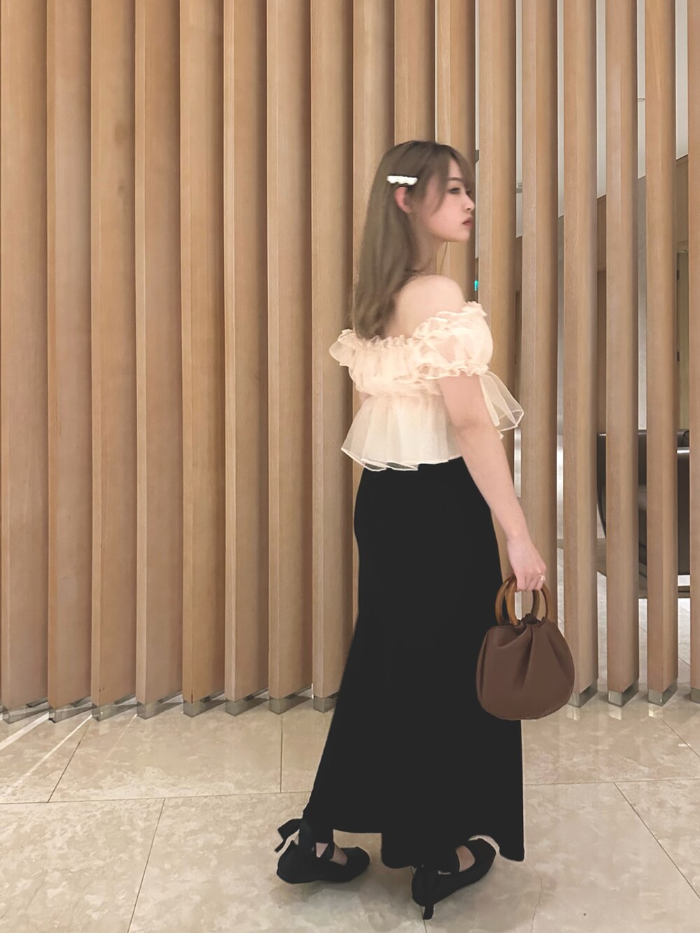 ピンク系のトップスを着用したレディースの夏コーディネートの2枚目の写真